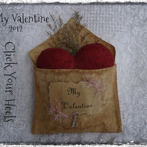 Könnte beinhalten: Ein brauner Papierumschlag mit einem roten Herzen darin. Der Umschlag hat einen Anhänger mit der Aufschrift "My Valentine".