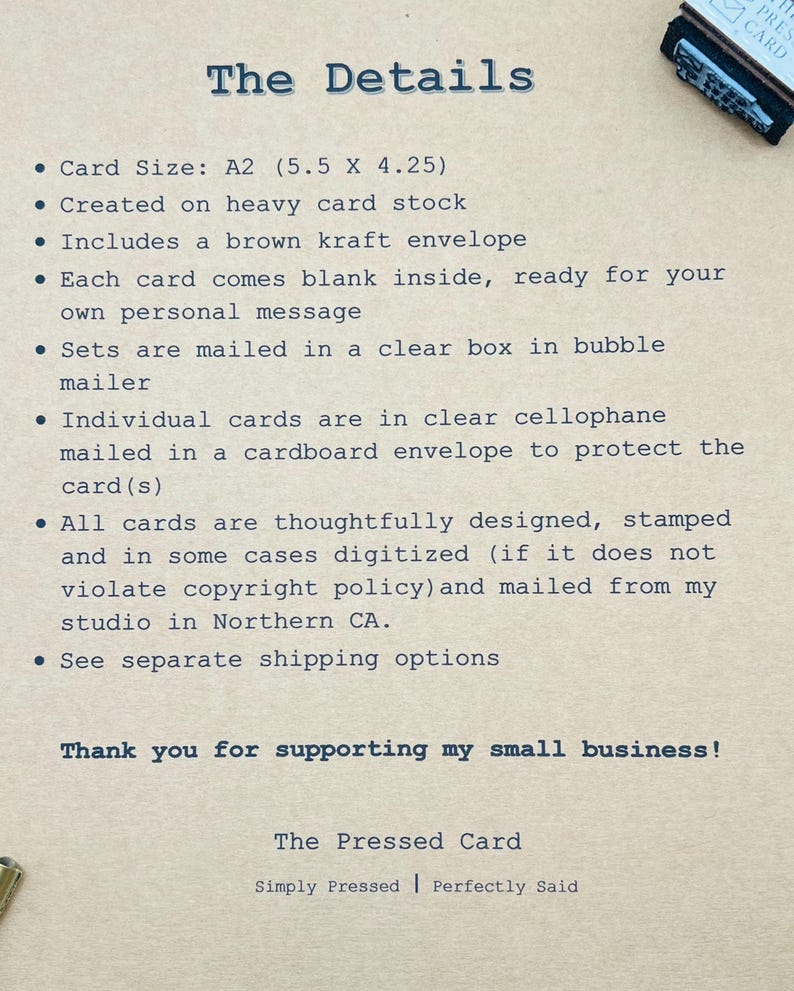 May include: A beige card with blue text detailing card specifications. The card is A2 size (14 x 10.8 cm), made from heavy card stock, and includes a brown kraft envelope. The text also mentions the cards are blank inside and mailed in a clear box.