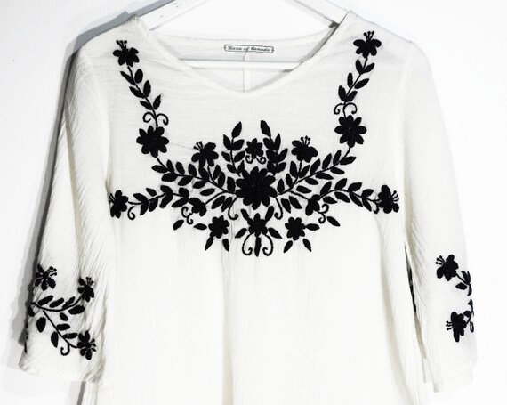 White top with blue embroidery