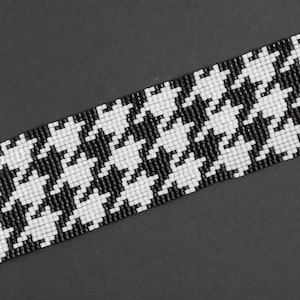 May include: Black and white beaded bracelet with a houndstooth pattern.