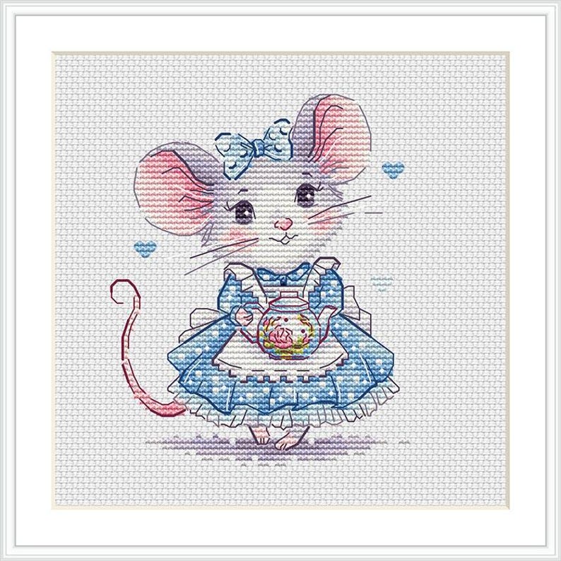 May include: A cross-stitch pattern featuring a white mouse with pink ears and a blue bow, wearing a blue dress with a white apron. The mouse holds a small, colorful teapot with floral details. Two small blue hearts are positioned near the mouse.