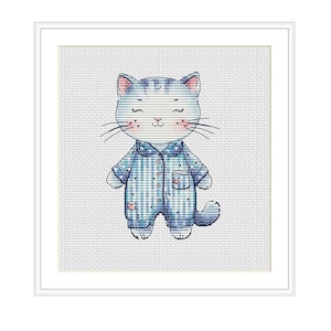 Puede incluir: Un gato azul y blanco a cuadros con pijama, nariz rosa y ojos cerrados. El gato está de pie sobre un fondo blanco.