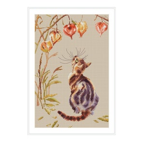 Könnte beinhalten: Eine braune getigerte Katze mit grünen Augen sitzt auf einem beigefarbenen Hintergrund und schaut zu einem Zweig mit orangefarbenen, gelben und roten Papierlaternen, die daran hängen.