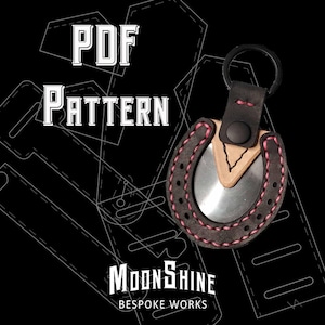 May include: Black leather horseshoe keychain with pink stitching and a silver insert. The keychain has a black ring and a leather strap. The image also includes the text "PDF PATTERN" and "Moonshine Bespoke Works".