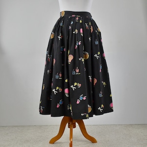 May include: A black midi skirt with a colorful print of various makeup items. The skirt is pleated and has a full silhouette.