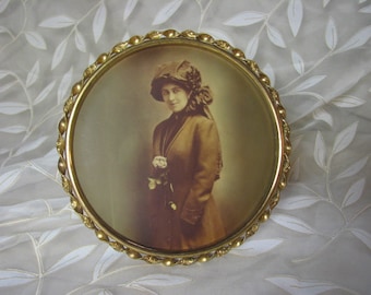 Edwardianskt tonat fotografi av en ung dam / mässingsram