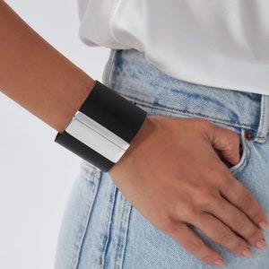 Our Nikol black bracelet is handmade of top quality leather and fastens with a plain magnetic clasp that comes silver plated. This statement piece can be worn with almost anything for a sophisticated style.