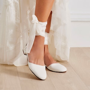 Philippa wedding lace up flats are handmade of top-quality leather featuring silk ankle ties and come with an alternative plain ankle strap, too. This romantic style has a rounded closed toe and open waist at the sides