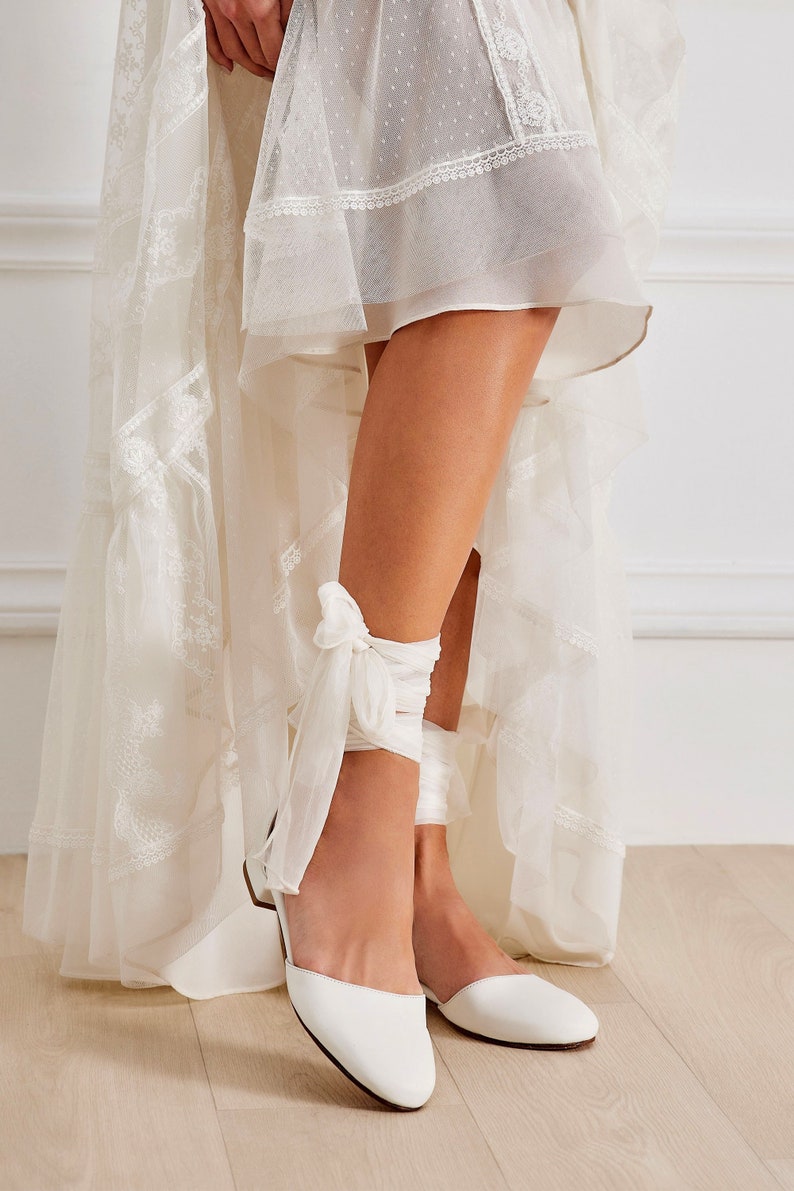 Philippa wedding lace up flats are handmade of top-quality leather featuring silk ankle ties and come with an alternative plain ankle strap, too. This romantic style has a rounded closed toe and open waist at the sides