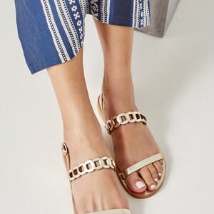 Gold leather flat sandals with handwoven over the foot strap, open toe and buckled strap