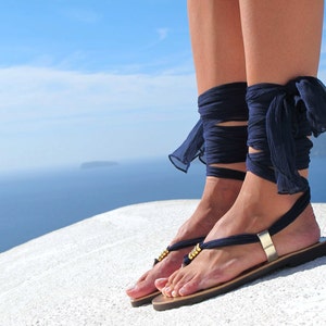 Handmade ribbon wrap sandals featuring Greek Chic Handmades signature interchangeable silk scarf laces and Greek meander embossed metal embellishments. Theese leather women boho flat sandals rest on a super light and comfortable rubber outsole