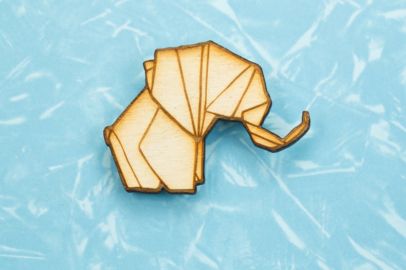 May include: A wooden origami elephant cutout, with a light brown colour, against a light blue background.