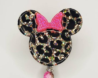 May include: Black and gold leopard print Minnie Mouse themed retractable badge holder with a pink bow and a pink and white bead.