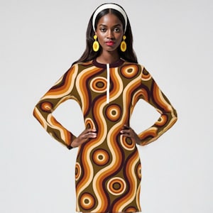 May include: A retro-style mini dress with a brown, orange, and cream swirl pattern. The dress has long sleeves and a white zipper. The model is wearing yellow knee-high boots and a white headband. Yellow earrings complete the look. The dress is a size small.