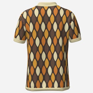 May include: A short-sleeved polo shirt with a retro pattern. The shirt features a repeating design of elongated, leaf-like shapes in shades of brown, orange, and cream. The collar and sleeve cuffs are a solid cream color.