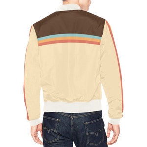 May include: Cream-colored bomber jacket with a brown upper back panel and colorful stripes. The jacket features a cream-colored body, red stripes down the sleeves, and white cuffs and collar. A stylish outerwear piece.