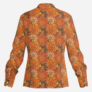 May include: A long-sleeved shirt with a colorful floral pattern in shades of orange, yellow, brown, and white. The shirt has a button-up collar and a fitted silhouette.