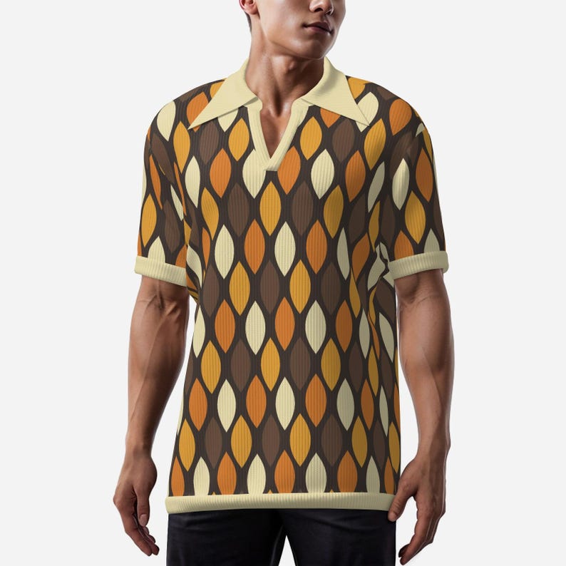 May include: A short-sleeved polo shirt with a retro pattern. The shirt features a cream-colored collar and cuffs, and a repeating pattern of brown, orange, and cream-colored leaf shapes. The shirt has a V-neck design.