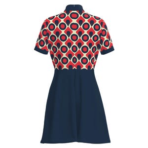 May include: A short-sleeved dress with a navy blue skirt and a patterned bodice. The bodice features a repeating design of red circles within navy blue diamonds, set against an off-white background. The dress has a high, navy blue collar.