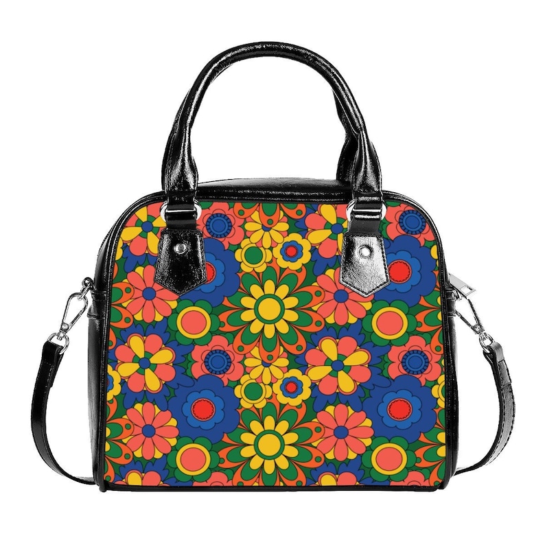 May include: A black handbag with a floral pattern. The pattern features colorful flowers in shades of red, orange, yellow, green, and blue.