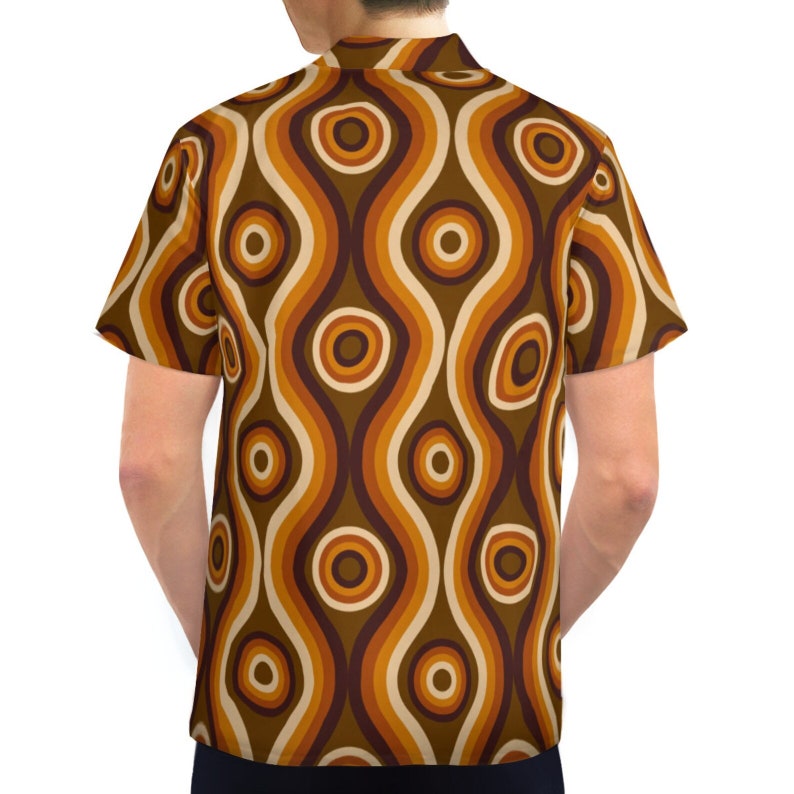 Pu&ograve; includere: Una camicia a maniche corte con bottoni e un motivo retr&ograve; anni '70 con linee ondulate e cerchi marroni, arancioni e crema.