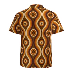 Pu&ograve; includere: Una camicia a maniche corte con bottoni e un motivo retr&ograve; di linee ondulate e cerchi marroni, arancioni e crema.