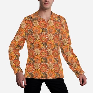 May include: A long-sleeved shirt with a colorful floral pattern in shades of orange, yellow, and brown. The shirt has a button-down collar and a relaxed fit.