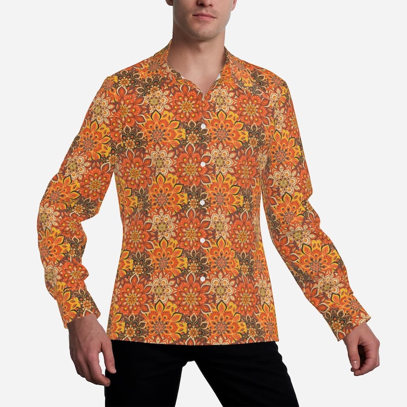 May include: A long-sleeved shirt with a colorful floral pattern in shades of orange, yellow, and brown. The shirt has a button-down collar and a relaxed fit.