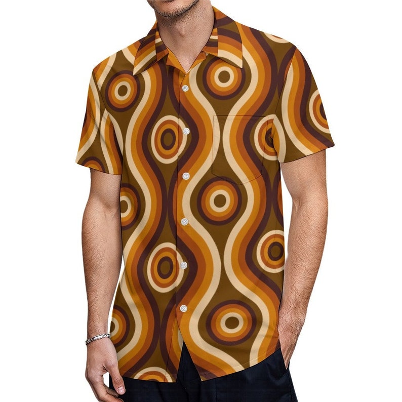 Pu&ograve; includere: Una camicia a maniche corte con bottoni e un motivo retr&ograve; di linee ondulate e cerchi marroni, arancioni e crema.
