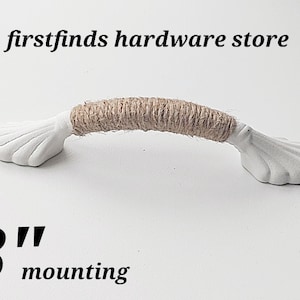 Peut inclure: Poignée de tiroir en céramique blanche avec une corde de jute brune enroulée autour du centre. La poignée mesure 7,6 cm de long et a un montage de 7,6 cm.