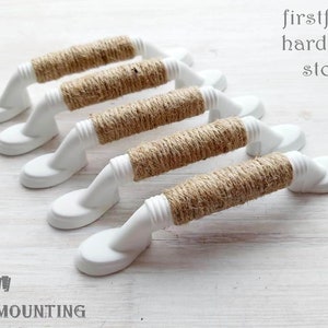 Peut inclure: Cinq boutons de cabinet blancs avec une plaque de montage de 7,6 cm. Chaque bouton est enveloppé de ficelle de jute naturelle.