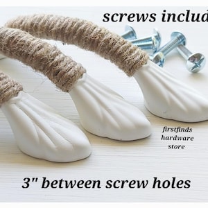 May include: White cabinet pulls with a rope-wrapped handle and a decorative base. The pulls are 3 inches between screw holes and come with screws. The text "screws included" and "firstfinds hardware store" are visible.