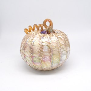 May include: A white glass pumpkin with a swirl pattern and a brown and purple glass stem.