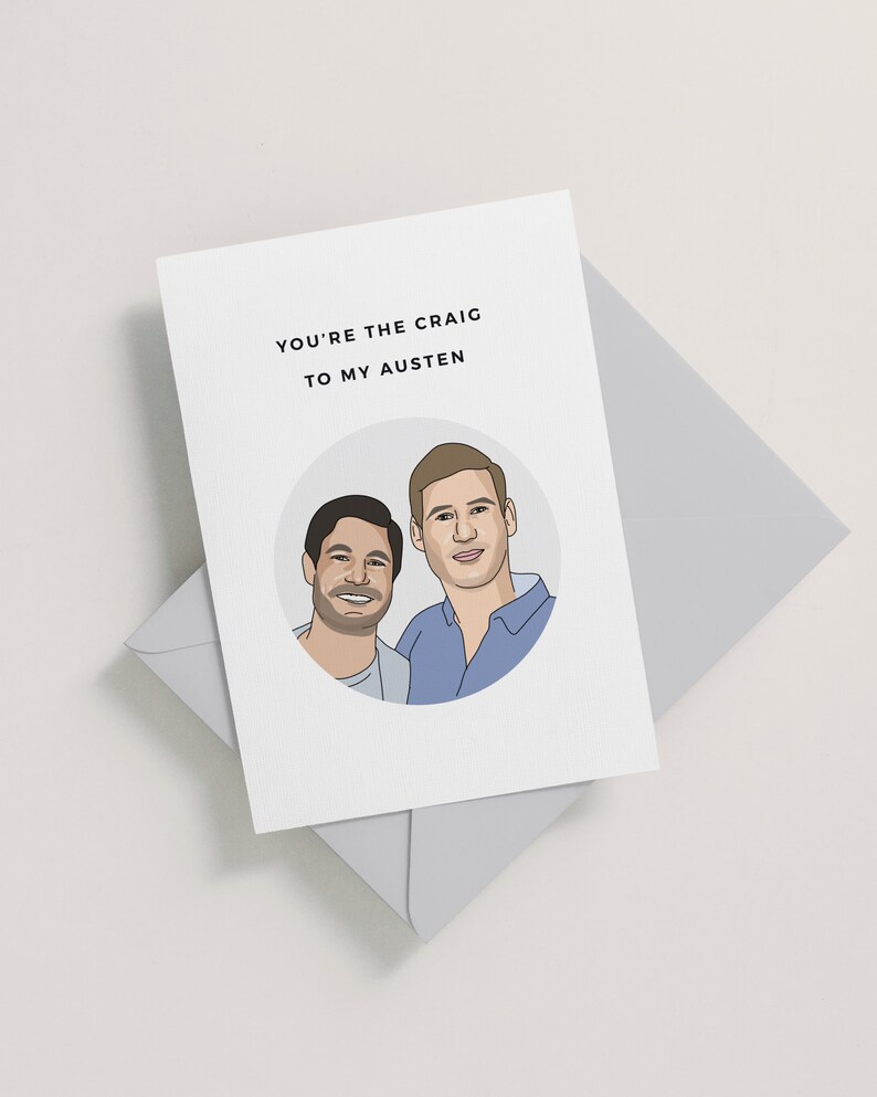 Op de afbeelding: Een kaart met een cartoonillustratie van twee mannen in een cirkel. De tekst op de kaart luidt "You're the Craig to my Austen."