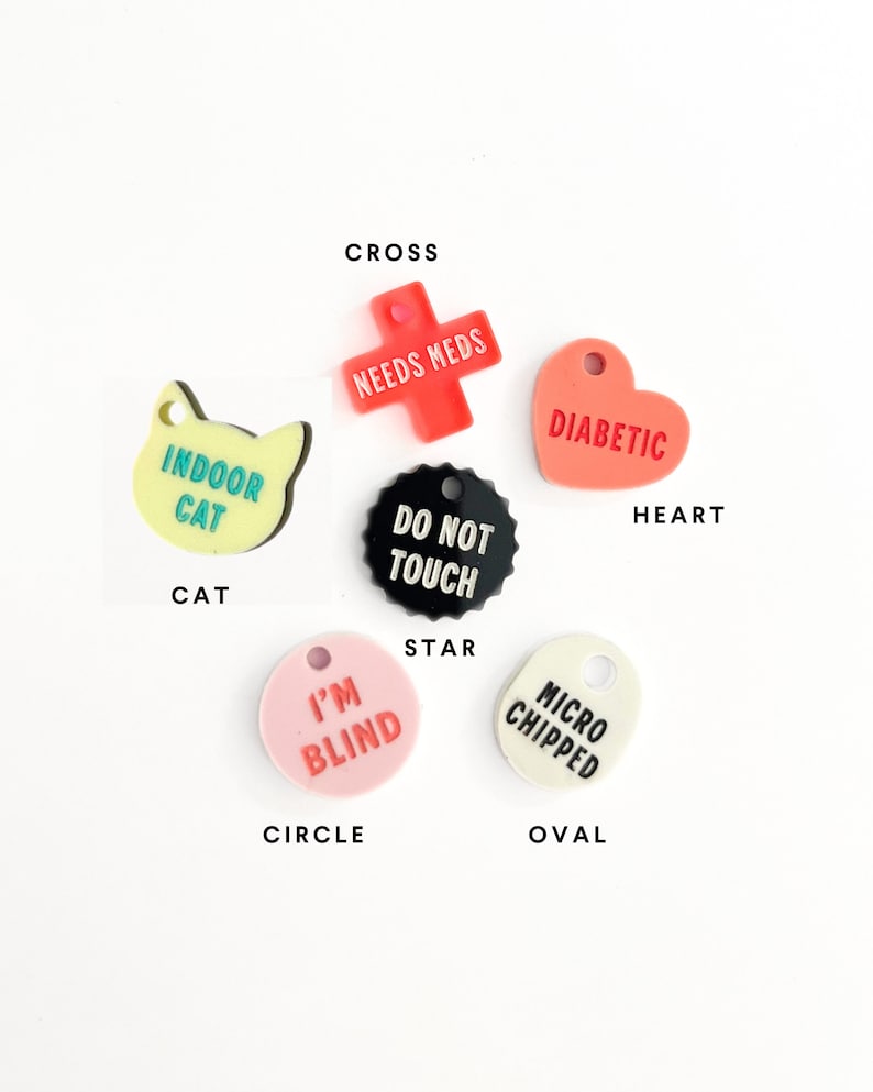 May include: Assortment of colorful pet ID tags in various shapes, including a cross, heart, star, circle, and oval. The tags feature text such as "Needs Meds", "Diabetic", "Do Not Touch", "I'm Blind", and "Micro Chipped".