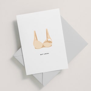 May include: A white card with a beige bra illustration and the text "EAT LOCAL" printed in black.