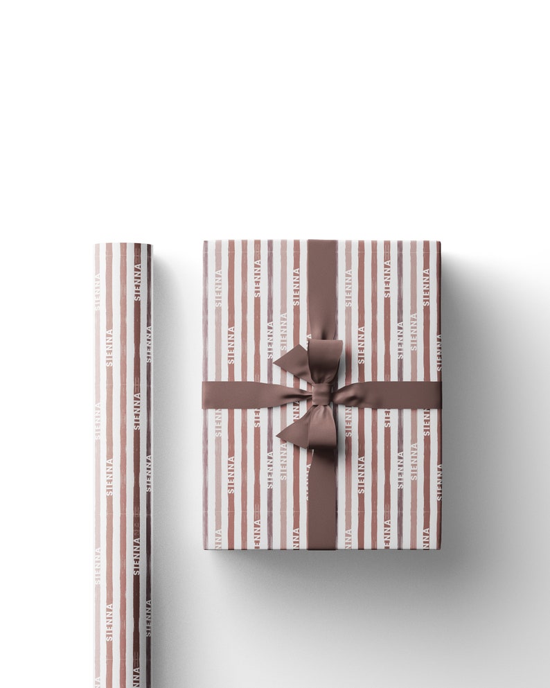 May include: Gift wrapping paper and a wrapped gift with a brown ribbon. The paper has vertical stripes in shades of brown and the word "SIENNA" repeated. The wrapped gift has a matching brown ribbon tied in a bow.