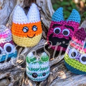 Puede incluir: Cinco juguetes de peluche tejidos a crochet con diferentes diseños y colores. Los juguetes están sentados sobre una superficie de madera. Los juguetes miden aproximadamente 10 cm de alto. Los juguetes son todos hechos a mano y únicos.