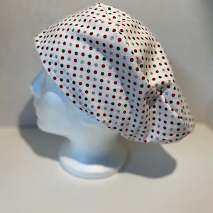 May include: White scrub hat with red, green, and silver polka dots.
