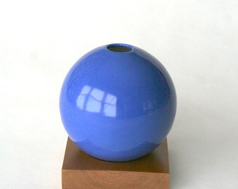 blue ceramic vase on wood base