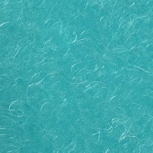 May include: A close-up of a teal blue textured paper with a fibrous, handmade appearance.