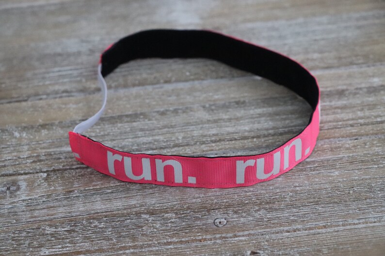 Puede incluir: Diadema rosa con el&aacute;stico negro y texto blanco que dice "run. run."