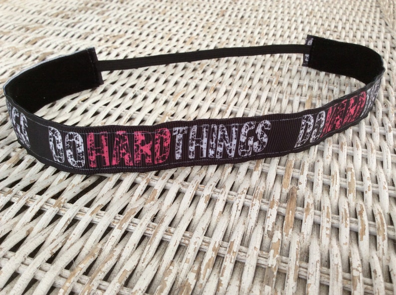 Puede incluir: Diadema negra con texto blanco y rosa que dice "DO HARD THINGS DAILY".
