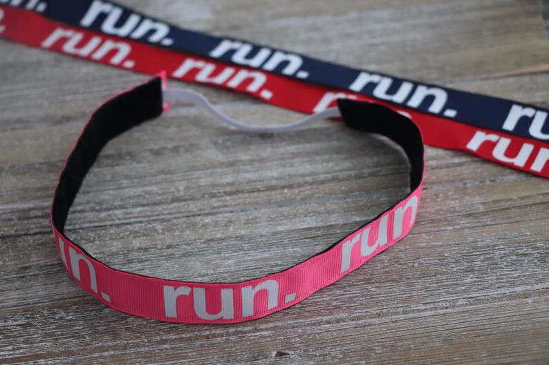 Puede incluir: Una diadema rosa con la palabra "run" impresa en blanco. La diadema est&aacute; hecha de un material suave y el&aacute;stico y tiene una banda el&aacute;stica negra.