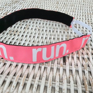 Puede incluir: Diadema rosa con el&aacute;stico negro y texto blanco que dice "run."