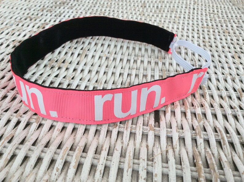 Puede incluir: Diadema rosa con el&aacute;stico negro y texto blanco que dice "run."