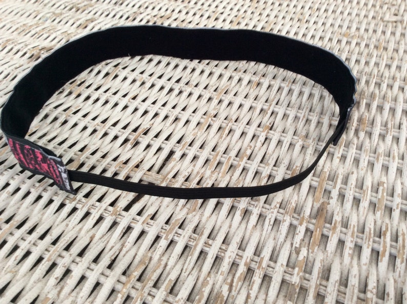 Puede incluir: Diadema el&aacute;stica negra con estampado gr&aacute;fico rosa y negro. La impresi&oacute;n incluye el texto "Life is Good".