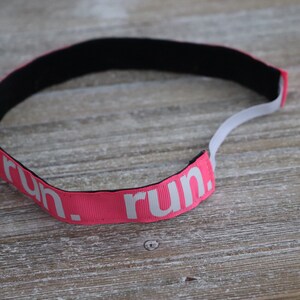 Puede incluir: Diadema rosa con "run." impreso en blanco.