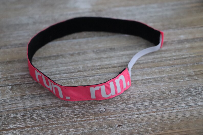 Puede incluir: Diadema rosa con "run." impreso en blanco.