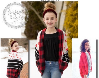 May include: A red and black plaid cardigan with a heart pattern. The cardigan is worn by a child with a red headband. The text "coffeen CARDIGAN" is at the top of the image. The text "PATTERN BROUGHT TO YOU BY: megan thoman for made for mermaids" is at the bottom of the image.